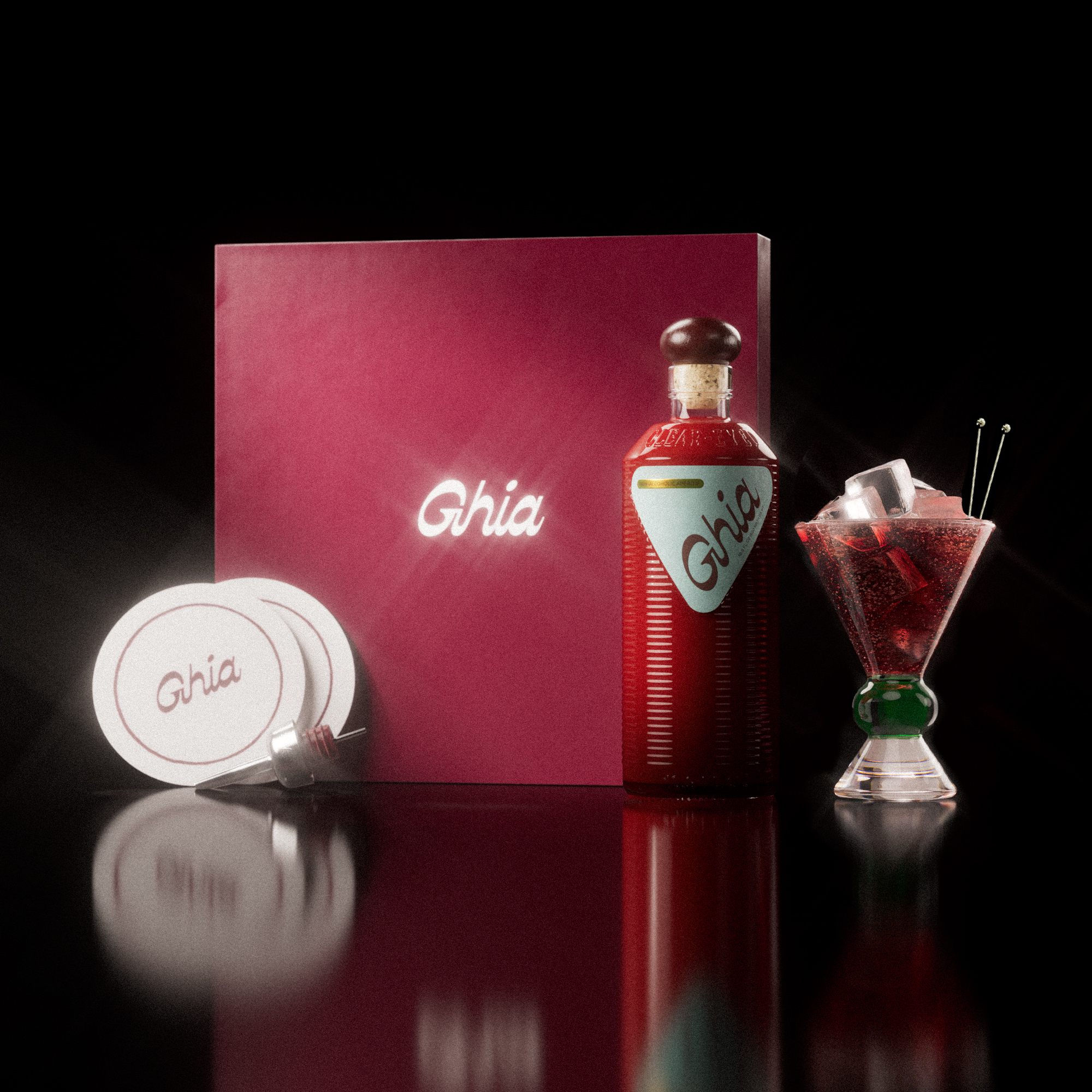 A Ghia non-alcoholic aperitif gift set with a burgundy box, paper coasters, 1 glass bottle of Original Apéritif, and a decorative cocktail glass that has a green and clear base.